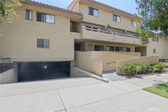 Front view of a multi-story building with recessed balconies and a gated entryway.