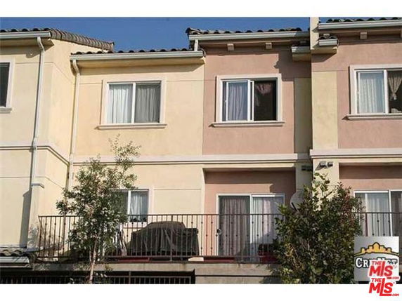 Front view of a two-story townhouse with a balcony.