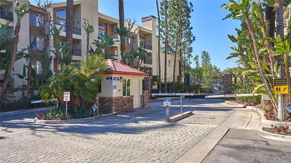 Front view of a multi-story residential building with a gated entrance.