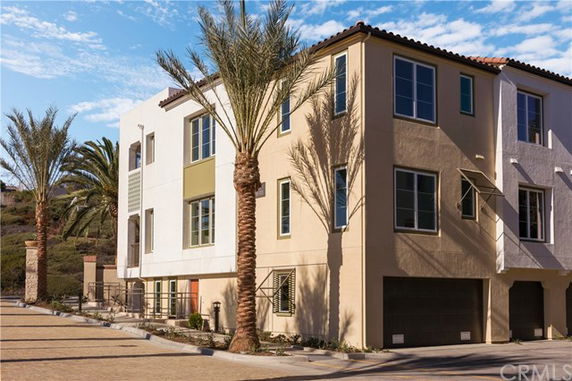 Front view of a multi-story building with a modern design and attached garages.