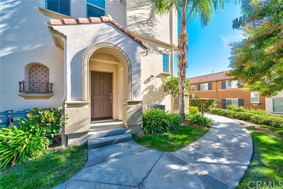 Front view of a house with an arched entrance and stucco exterior.