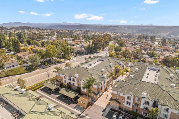 Panoramic view of residential buildings with green rooftops and surrounding neighborhood.