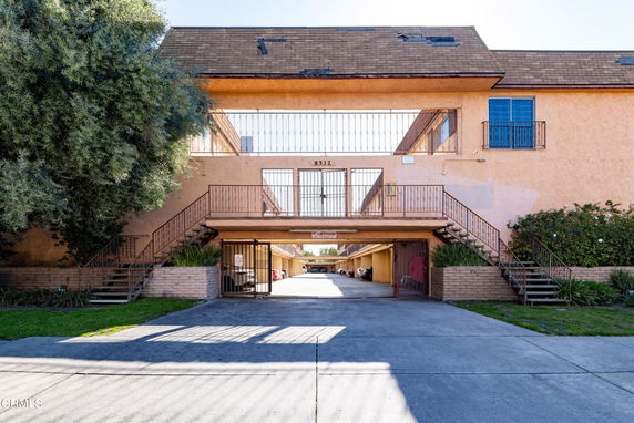 Front view of a two-story apartment building with exterior staircases and a drive-through entry.
