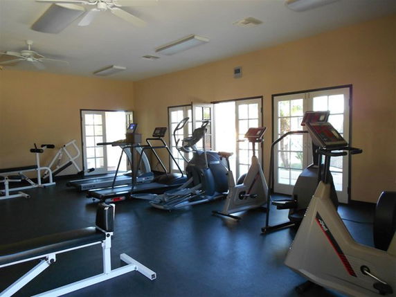 Room with gym equipment like treadmills and exercise bikes.