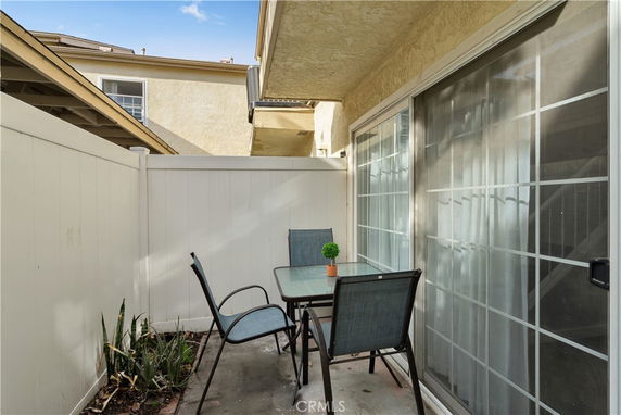 Outdoor patio area with a table and chairs next to a building.