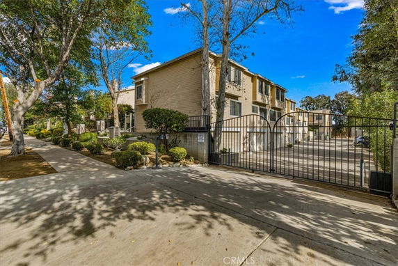Front view of a multi-story apartment building with a gated entrance.
