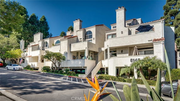 Front view of a multi-story residential building with balconies and chimneys.
