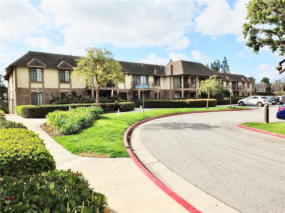 Front view of a multi-story residential building with Tudor-style architecture.