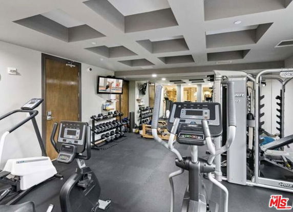 Indoor gym area with exercise equipment and weights.