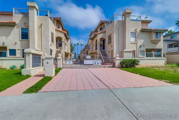 Front view of a two-story residential building with gated entrance.