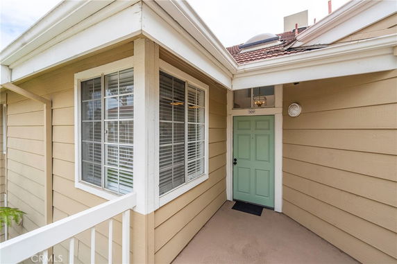 Front view of a house entrance with a green door and large windows.