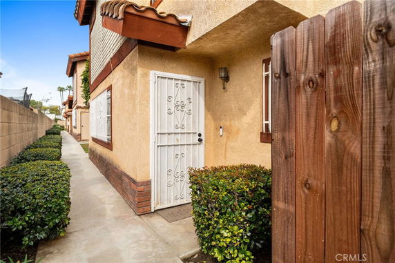 Front view of a two-story house with a gated entrance and pathway.