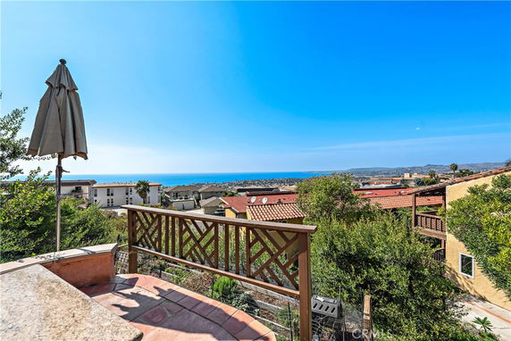 Panoramic view from a building showcasing a vast cityscape with ocean in the background.
