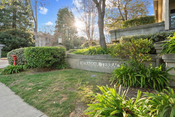 Front view of a building entrance with the name 'Miramar Terrace' displayed on a stone wall.