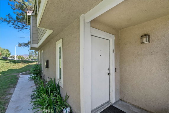 Front view of a house entrance with a small pathway and side windows.