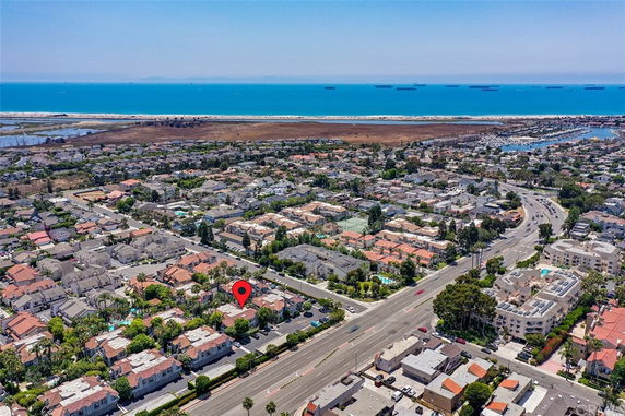 Panoramic view of a coastal residential area with houses and the ocean in the background.