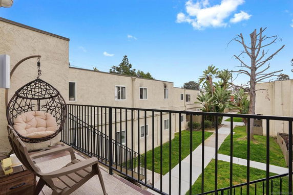 View from a balcony overlooking the exterior of a multi-unit building complex.