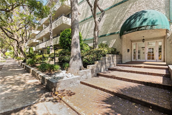Front view of a multi-story building with balconies and a canopy entrance.