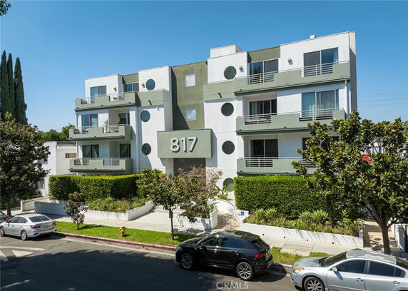 Front view of a multi-story apartment building with balconies.