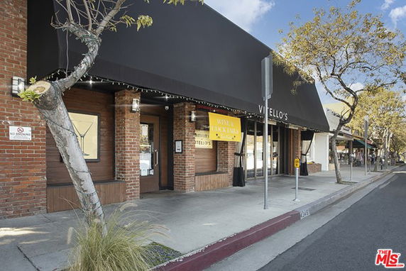 Front view of a commercial building with a brick exterior and black awning.