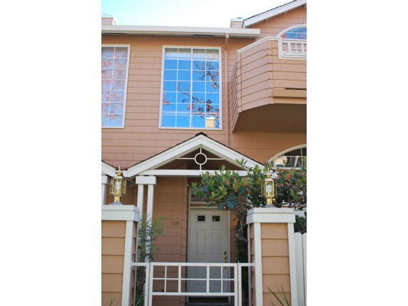 Front view of a two-story house with large windows and a covered entrance.
