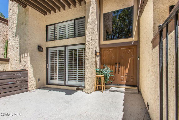 Front view of a house with a textured exterior wall and a large double door entrance.