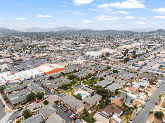 Aerial view of a residential and commercial area with multiple buildings and parking spaces.