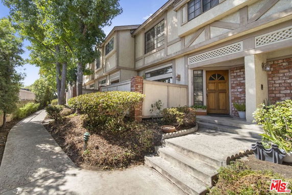 Front view of a two-story residential building with a walkway and entrance steps.
