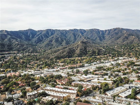 Panoramic view of a town with mountains in the background.