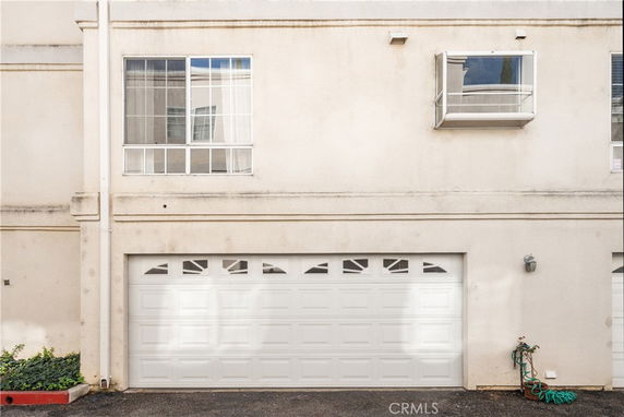 Front view of a building with a garage door on the lower level and windows above.