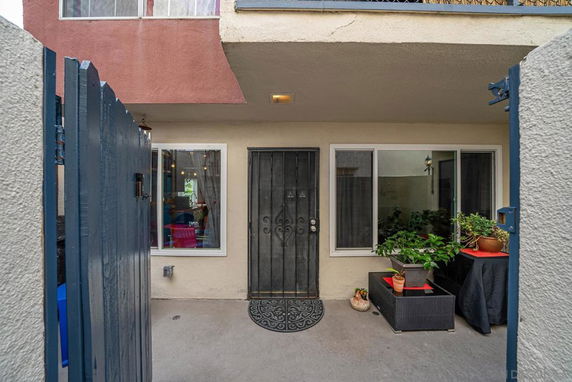 Front view of a house entrance with a metal door and windows on either side.