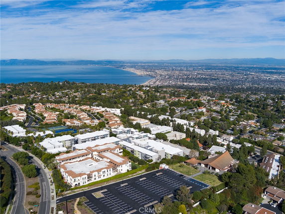 Panoramic view of a coastal city with residential buildings and ocean in the background.
