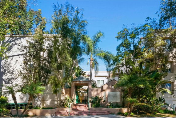 Front view of a multi-story building with trees and landscaping.