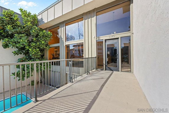Front view of a building entrance with large windows and a glass door.