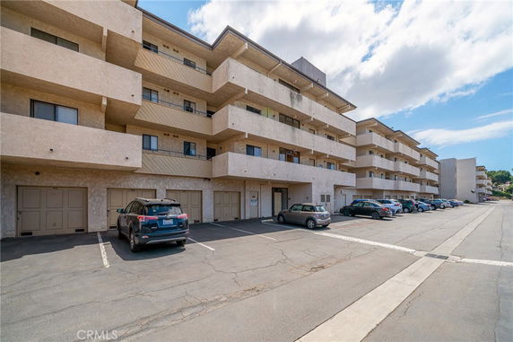 Outdoor parking area in front of a multi-story apartment building