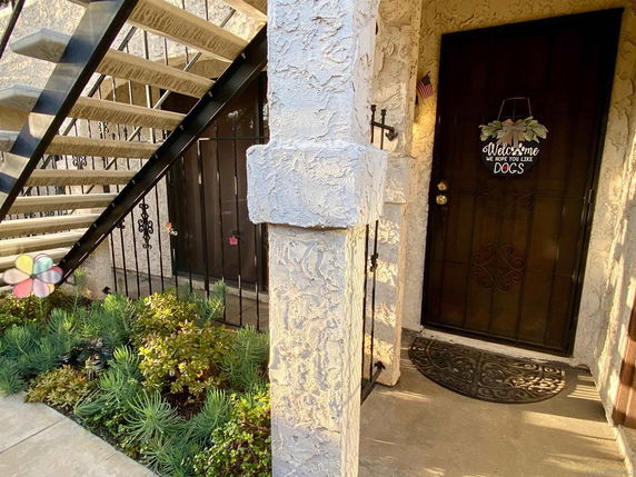 Front view of an entrance to a building with stairs and decorative door.