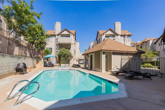 Outdoor swimming pool with a surrounding view of a multi-story building.
