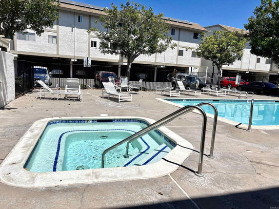 Outdoor swimming pool area with a small hot tub.
