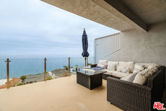 Outdoor patio area with seating and ocean view.