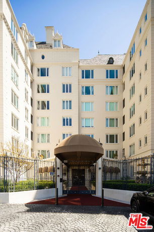 Front view of a multi-story building with an arched entrance canopy.
