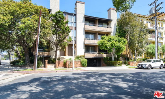 Front view of a multi-story residential building with balconies.