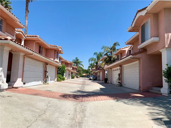 Front view of multiple two-story houses with garages and a driveway.