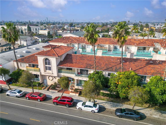 Front view of a multi-story residential building with red tiled roof and balconies.