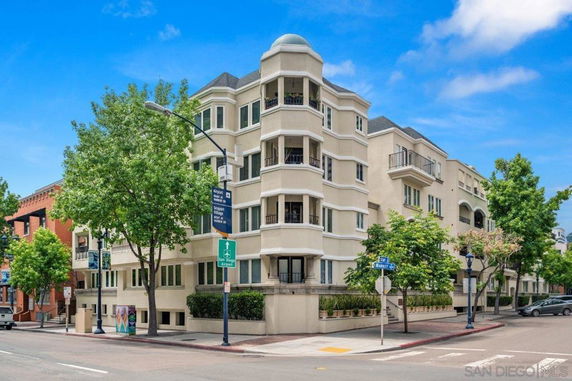 Street view of a multi-story building on a corner lot with a unique design.