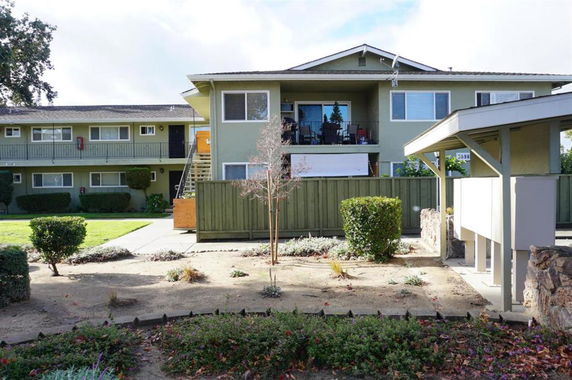 Front view of a two-story apartment building with balconies.