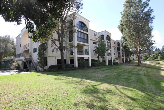 Front view of a multi-story apartment building with balconies.