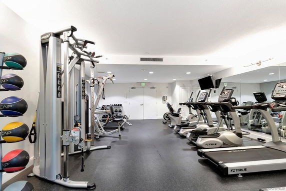 Indoor gym area with exercise machines and equipment.