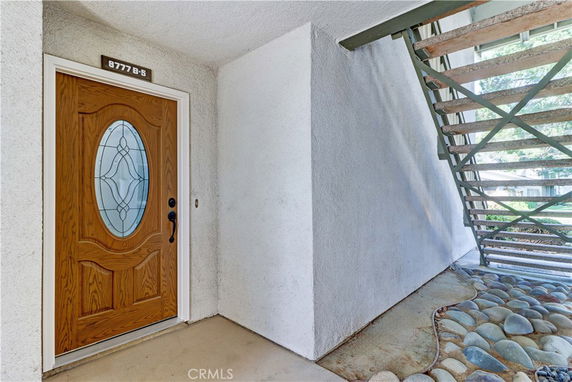 Entrance of a building with a wooden door and decorative oval glass panel.