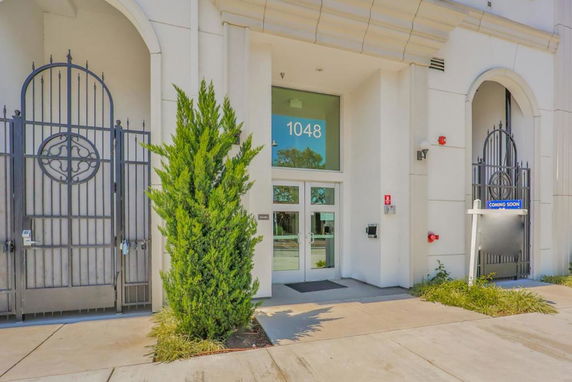 Front view of a building entrance with glass doors and decorative metal gates.