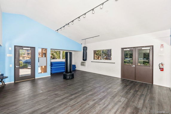 Interior view of a recreational room with punching bags and exercise mats.